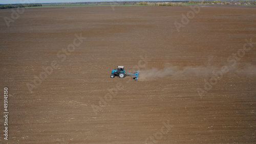 Farming: a farmer on a tractor works the field before sowing