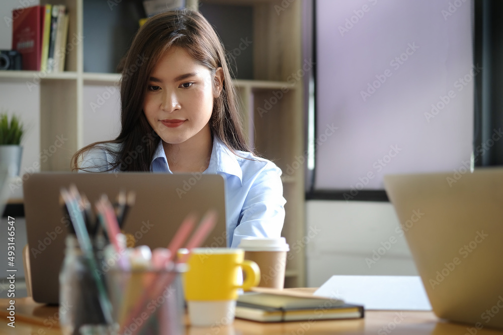 Asian female office worker using laptop computer at comfortable workplace. Asian female office worker using laptop computer at comfortable workplace.