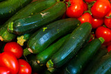 Close-up view of fresh ripe zucchinis and tomatoes in market.