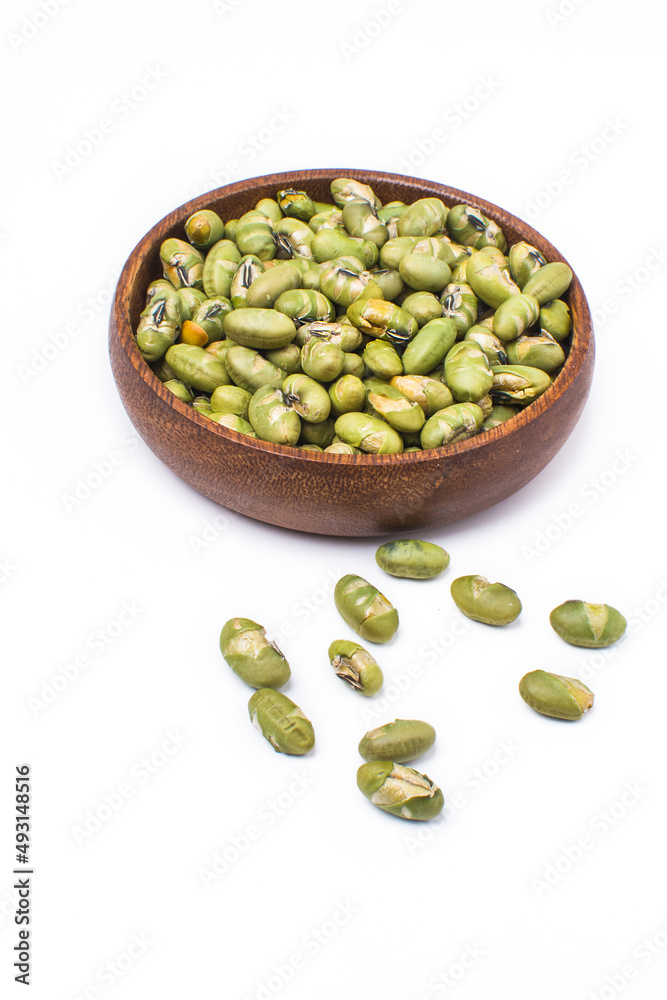 salted bean seeds in a wooden bowl. Isolated on white background. salted bean seeds in a wooden bowl. Isolated on white background.