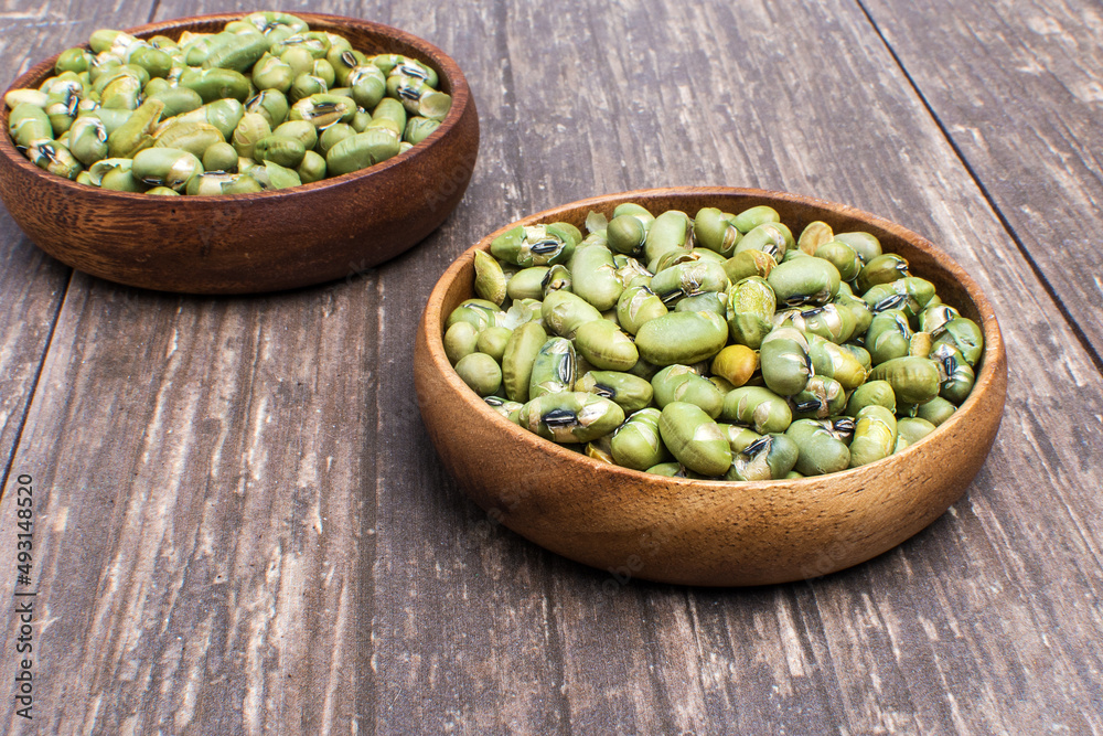 delicious salty green bean seeds in a wooden bowl on a wooden table delicious salty green bean seeds in a wooden bowl on a wooden table