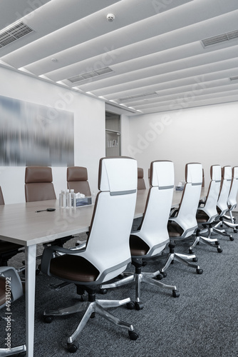 	
Business meeting room or Board room interiors.Orange chairs and wood-grain conference tables inside.	
