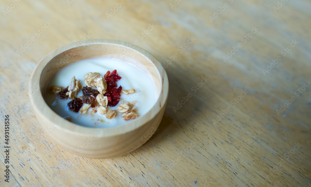 Dried fruits and whole grains in a yogurt bowl on a wooden table. Dried fruits and whole grains in a yogurt bowl on a wooden table.
