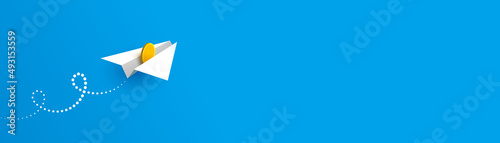 Horizontal banner with paper plane and gold coin over blue background