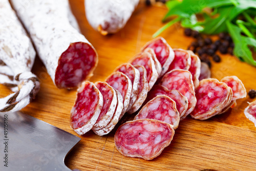Fuet, traditional spanish smoked pork salami on a wooden kitchen board