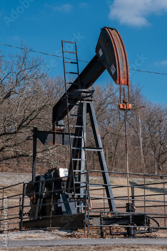 Oil well pumping in front of blue sky