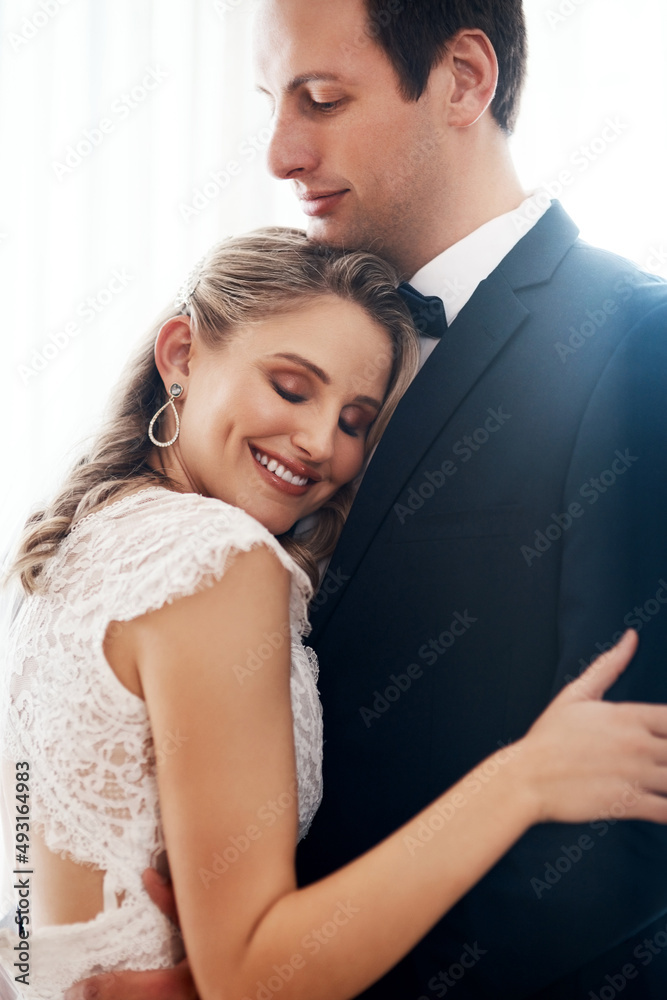 You put your arms around me and I was home. Cropped shot of a happy young couple standing indoors and hugging each other affectionately after their wedding. You put your arms around me and I was home. Cropped shot of a happy young couple standing indoors and hugging each other affectionately after their wedding.