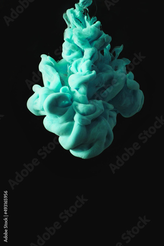Turquoise ink drop in clear water and black background. abstract image for background or color reference.