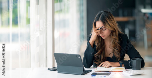Quadro em tela Stressed business woman working at office on laptop closed her eyes, looking worried, tired and overwhelmed