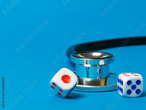 Close up photo of dices with stethoscope. Postcode lottery healthcare concept.