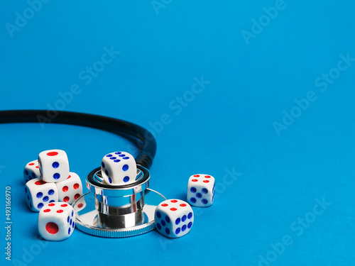 Close up photo of dices with stethoscope. Postcode lottery healthcare concept.