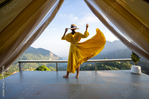 Asian female tourist in beautiful yellow dress, beautiful sky and mountains of nature, Chiang Rai, Thailand.