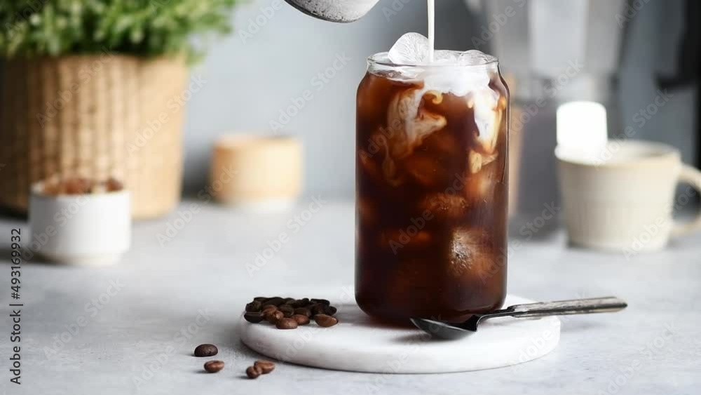 girl pouring milk into cold coffee, selective focus girl pouring milk into cold coffee, selective focus