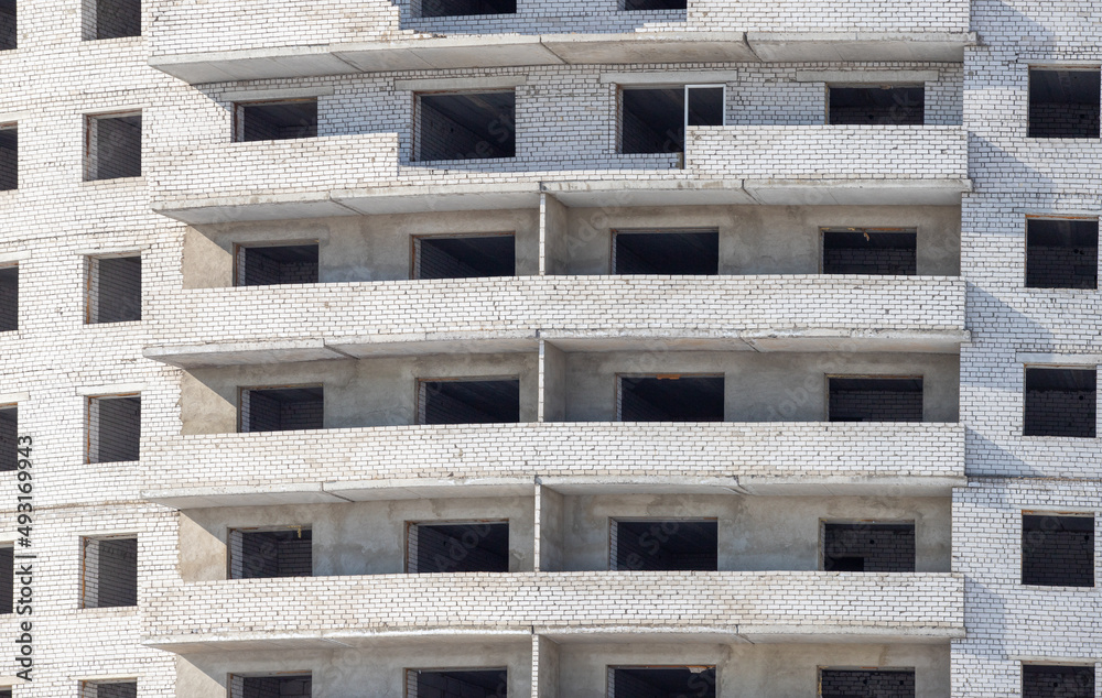 A multi-storey brick house is under construction. A multi-storey brick house is under construction.