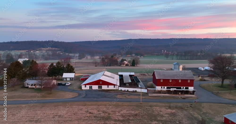American farm with red barn buildings and house. Rural agriculture scene in Pennsylvania at winter sunrise. American farm with red barn buildings and house. Rural agriculture scene in Pennsylvania at winter sunrise.