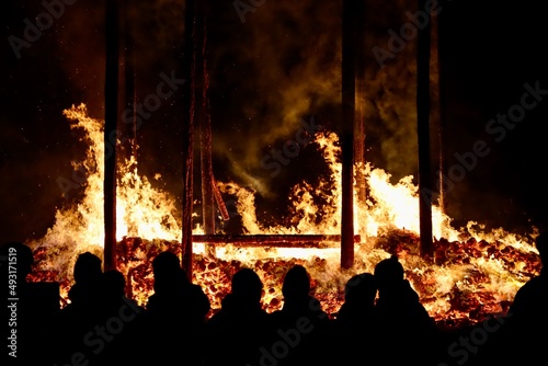 Buergbrennen festival in Luxembourg. Celebrating end of winter beginning of spring by burning mock castles. Black silhouettes of people admiring fire photo