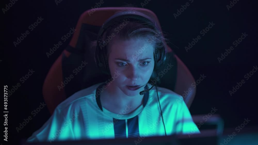 HANDHELD, Portrait of an emotional female gamer in headphones, plays a video game, cyber sportsman shouts and communicates with the team, tense moment. HANDHELD, Portrait of an emotional female gamer in headphones, plays a video game, cyber sportsman shouts and communicates with the team, tense moment.