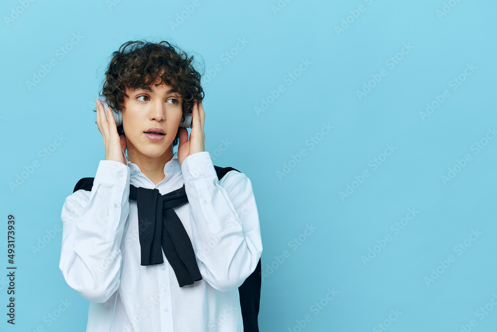 guy technology headphones in a white shirt with sweater isolated backgrounds guy technology headphones in a white shirt with sweater isolated backgrounds