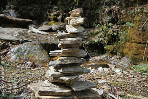 Fototapeta Naklejka Na Ścianę i Meble -  Prayer stone stacks among natural landscape of waterfall cascade and green forest park