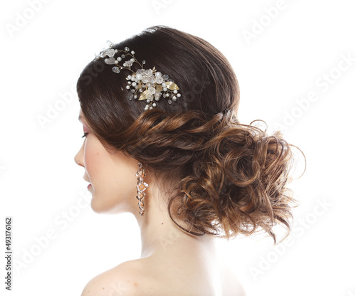 Wedding luxury hairstyle with a diadem. Young bride posing on a white background.