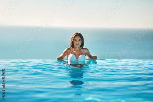 The pool is the perfect place to spend summer. Portrait of an attractive young woman spending some time in the pool.
