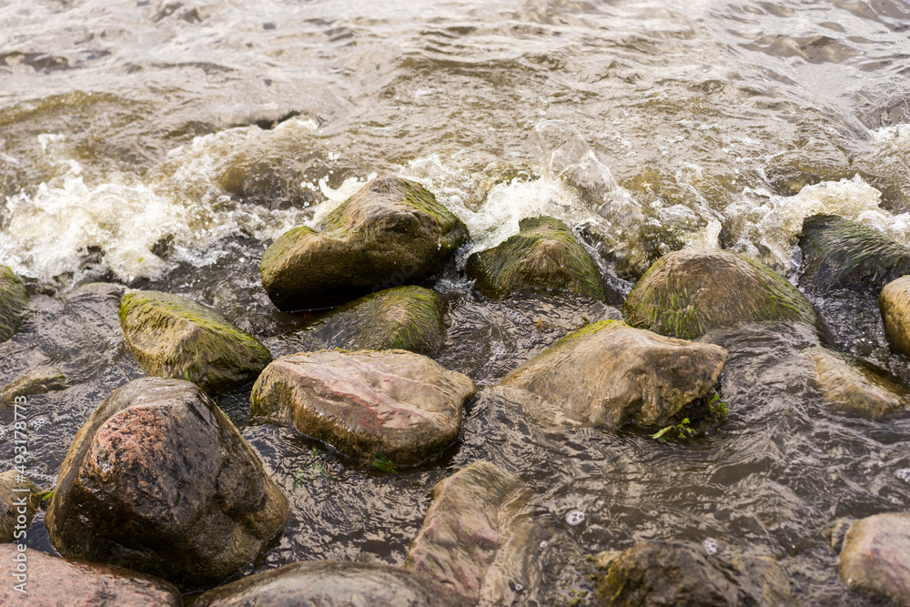 Sea stones and waves on the beach. Summer background. Sea stones and waves on the beach. Summer background.