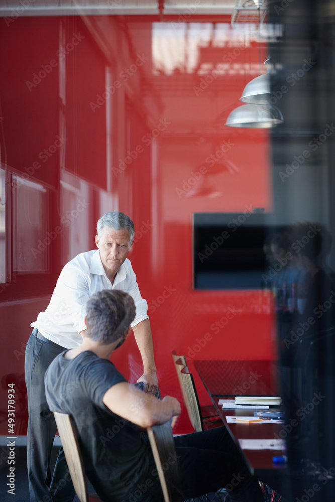 Serious strategizing. Shot of two handsome businessmen having a discussion in the office.