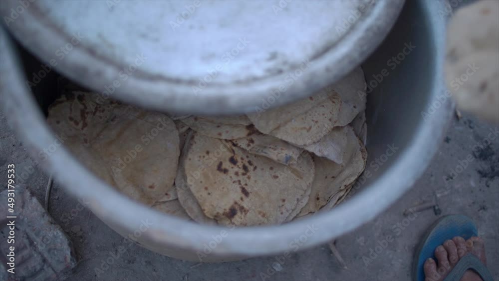 Indian bread known as Chapati or Roti kept in big container. Traditional Indian way of making Roti or Chapati in outdoor stove. High quality 4k footage Indian bread known as Chapati or Roti kept in big container. Traditional Indian way of making Roti or Chapati in outdoor stove. High quality 4k footage