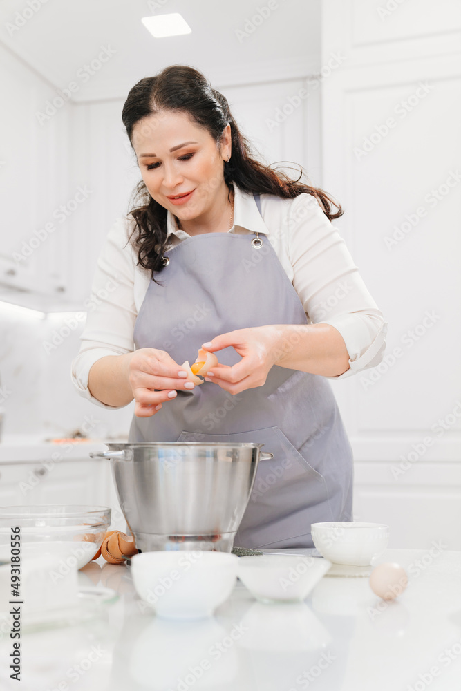 A woman breaks an egg and separates yolks from proteins A woman breaks an egg and separates yolks from proteins