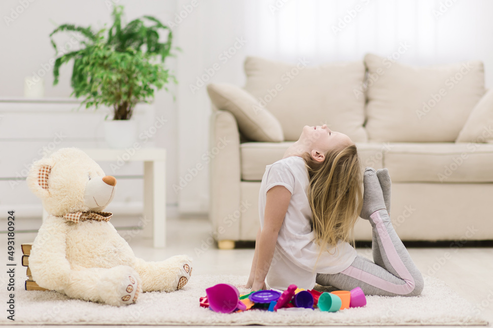 Photo of little girl doing gymnastics on the floor. Photo of little girl doing gymnastics on the floor.
