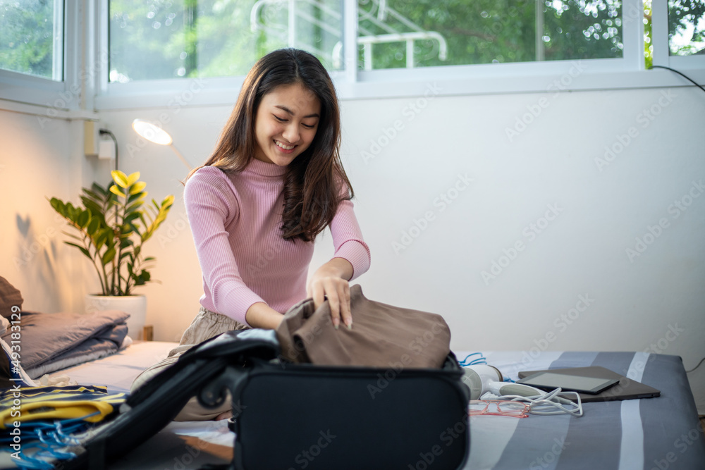 Woman Packing clothes into luggage at home, preparing to travel Woman Packing clothes into luggage at home, preparing to travel