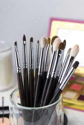 Makeup brushes against the background of shadows and sculptures. Make-up artist's desk