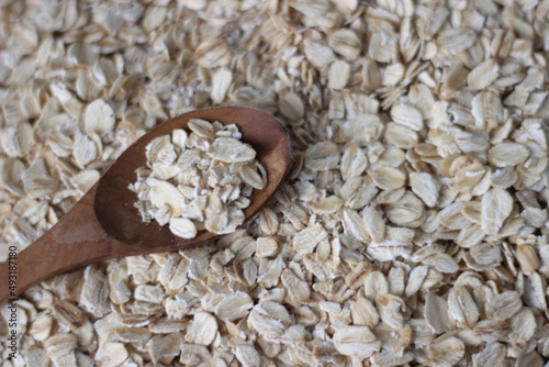 a spoon of oatflakes in the oats spread. healthy diet background, wallpaper ideas. photo