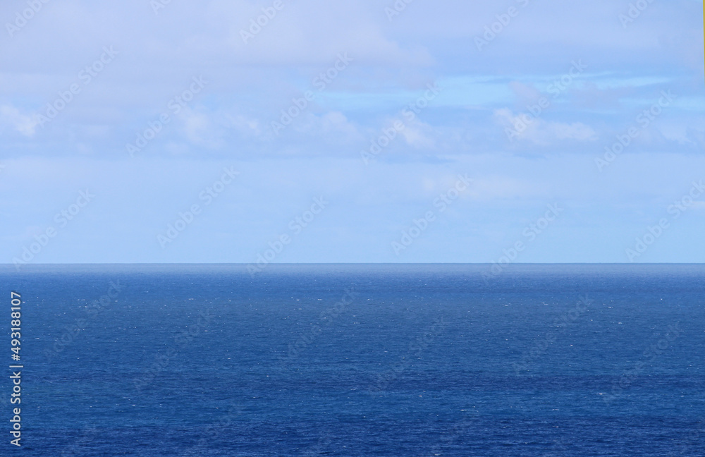 Flat blue ocean, straight horizon, blue sky and soft clouds. Sydney Australia Flat blue ocean, straight horizon, blue sky and soft clouds. Sydney Australia