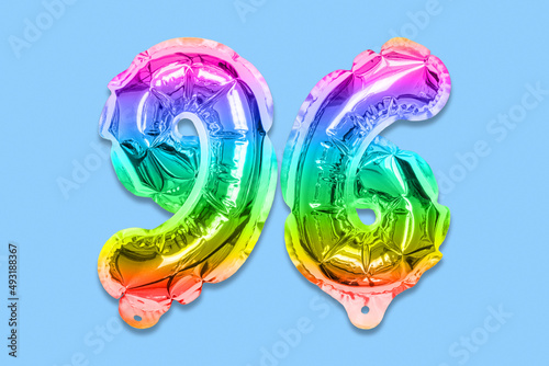 Rainbow foil balloon number, digit ninety six on a blue background. Birthday greeting card with inscription 96. Top view. Numerical digit. Celebration event, template.