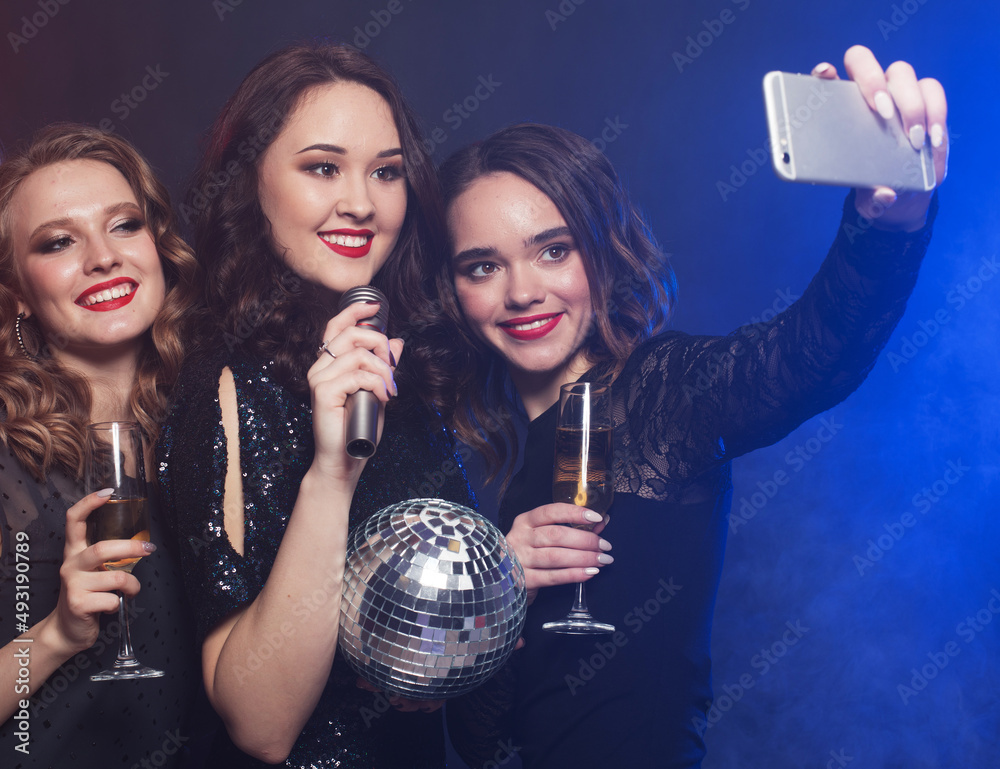 Group of glamour women in luxury black dresses drinking champagne and having fun with karaoke, selfie time. Group of glamour women in luxury black dresses drinking champagne and having fun with karaoke, selfie time.