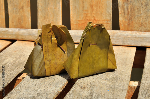 Traditional Indonesian food wrapped in banana leaves and cooked by steaming photo