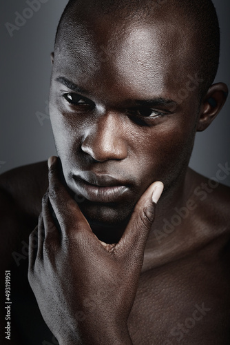 Hes the silent thinking type. An african male looking thoughtful in studio.