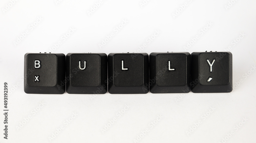 Bully text created with keyboard keys isolated on white background, white bully letters on black keyboard, top view Bully text created with keyboard keys isolated on white background, white bully letters on black keyboard, top view