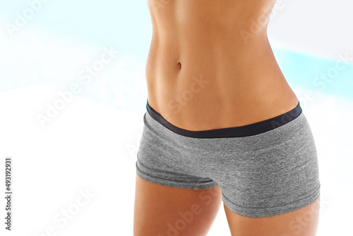 You earn your body. Cropped shot of a woman with a toned stomach posing outdoors in sportswear.