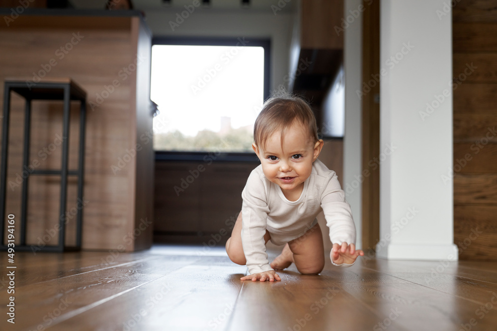 Caucasian little baby girl smiling and crawling at home Caucasian little baby girl smiling and crawling at home