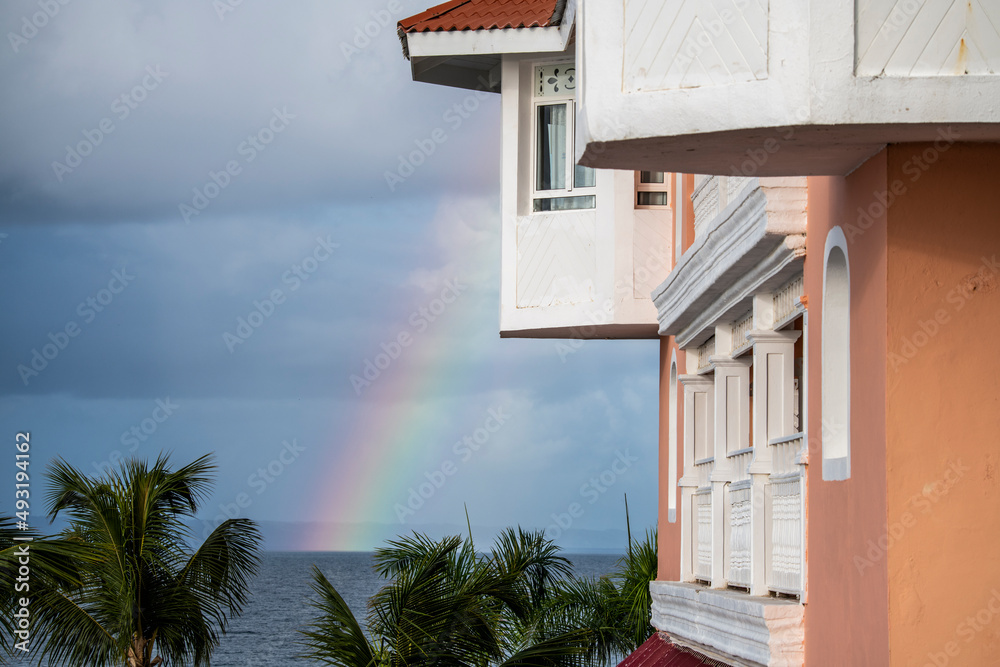Naklejka premium landscape with a rainbow after the rain against the background of buildings 
