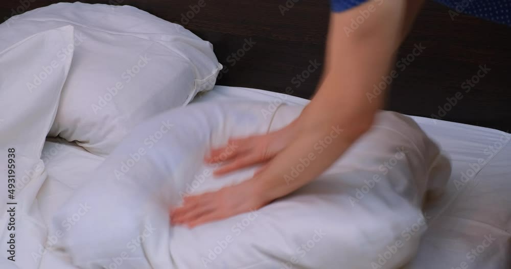 A man makes his own bed in the bedroom in the morning. A man makes a bed in a hotel. The concept of household chores, daily routine in the morning, lifestyle. making the bed A man makes his own bed in the bedroom in the morning. A man makes a bed in a hotel. The concept of household chores, daily routine in the morning, lifestyle. making the bed