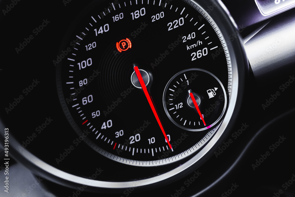 Car speedometer, luxury dashboard with glowing red indicators close-up view, background photo Car speedometer, luxury dashboard with glowing red indicators close-up view, background photo