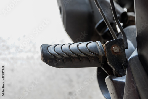 close up of motorcycle foot peg made of iron and black rubber