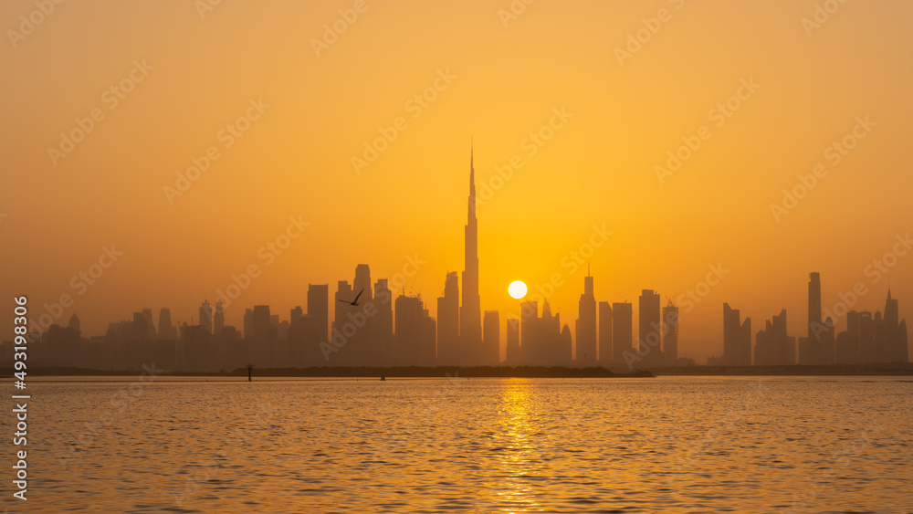 Orange sunset behind the Dubai skyline