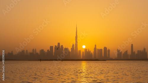 Orange sunset behind the Dubai skyline