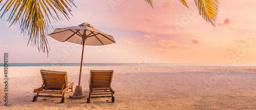 Fototapeta Naklejka Na Ścianę i Meble -  Beautiful panoramic nature. Tropical beach sunset as summer island landscape with chairs umbrella palm leaves calm sea shore, coast. Luxury travel panoramic destination banner for vacation or holiday