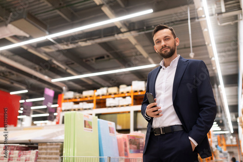 Quadro em tela presentable owner of a hardware store in a business suit looks at the camera on