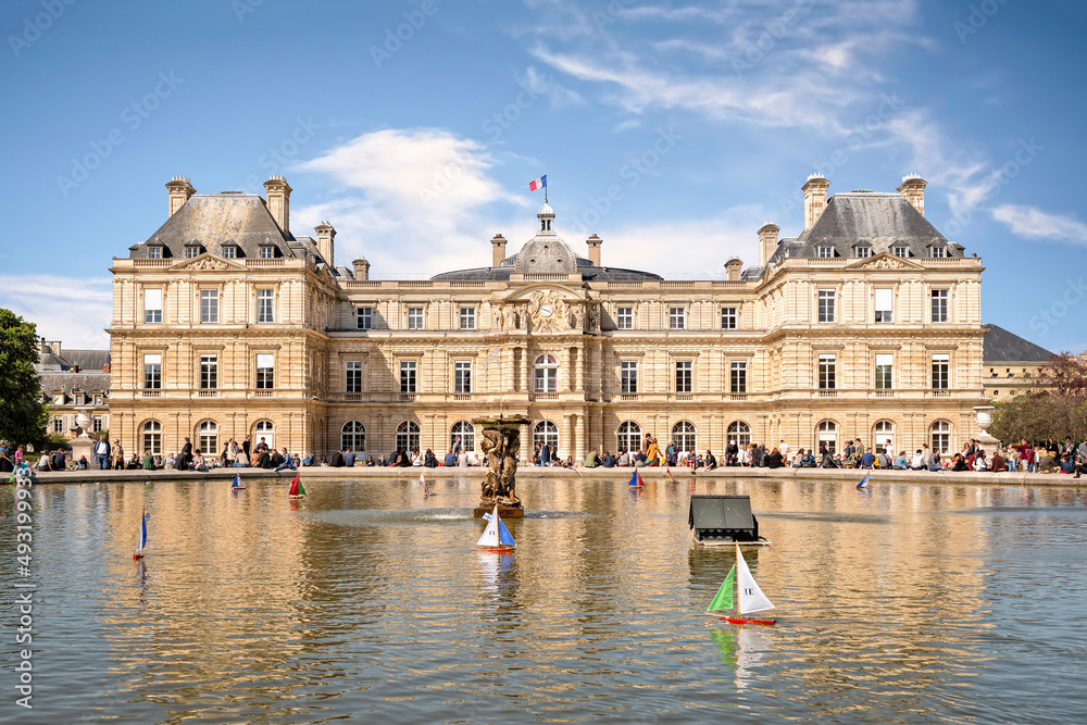 Parisians and tourists having relax at pond next to Luxembourg Palace in Paris. Palace was built in 1615–1645 to be royal residence of the regent Marie de Médicis, mother of Lou